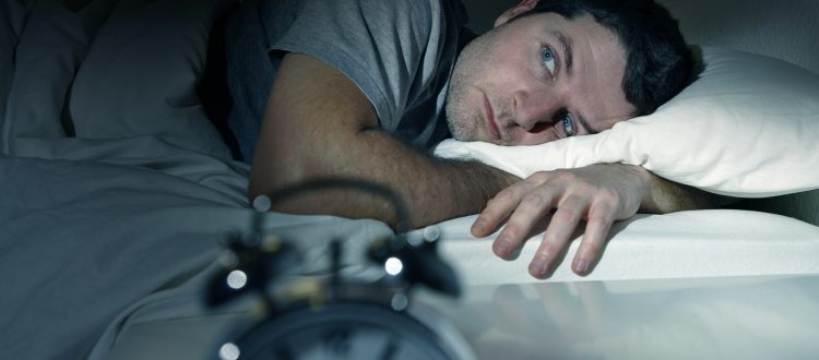man in bed with eyes opened suffering insomnia sleep disorder